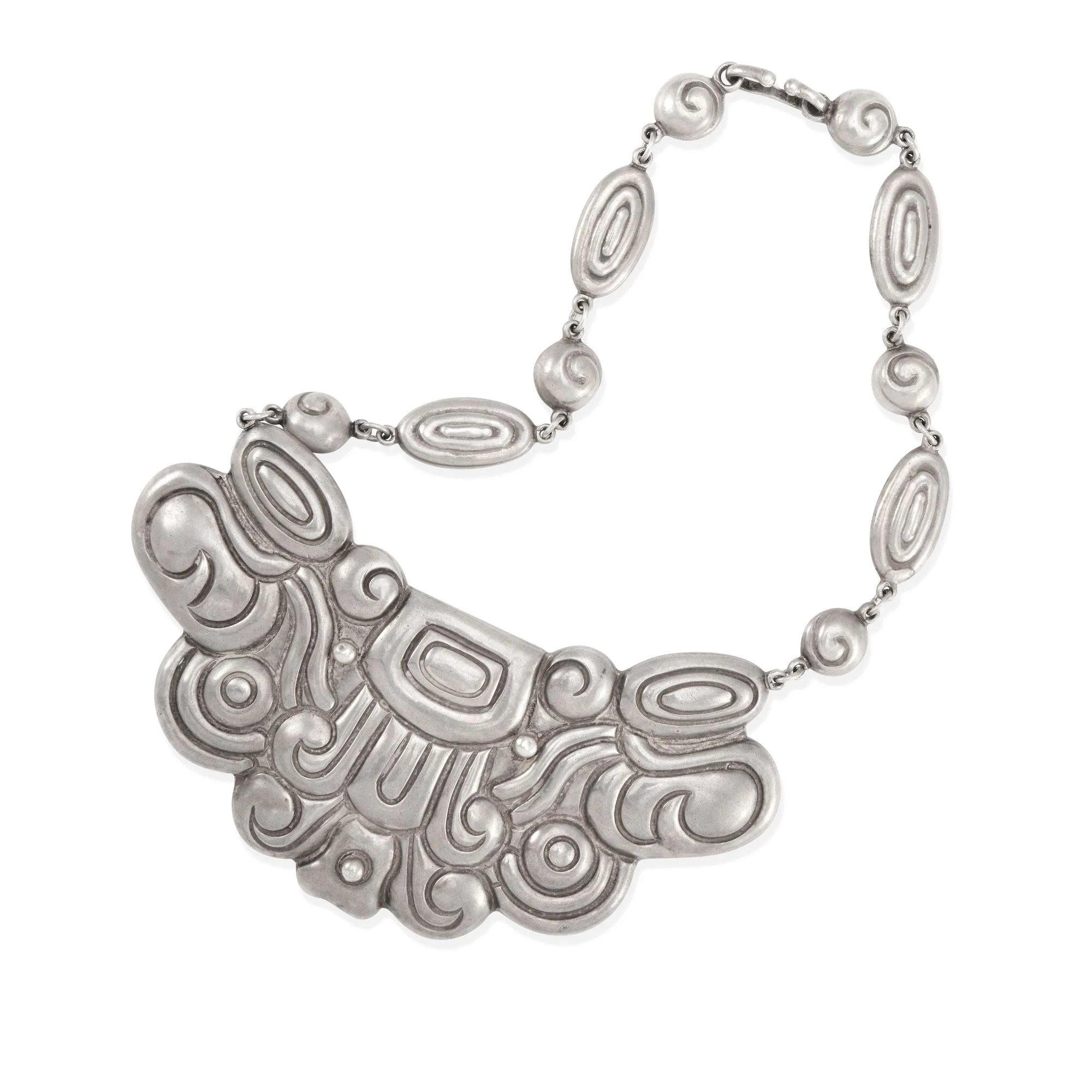 Silver bib necklace worked in repoussé scrolls and spirals, hung from a chain of oval and spiral links, by Los Castillo